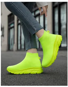 Vue détaillée de côté des baskets en maille jaune néon sur la rue en asphalte