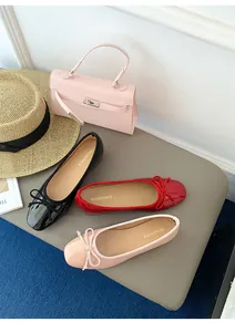 Stylish French bow ballet flats displayed in red, black, and pink colors on a grey bench