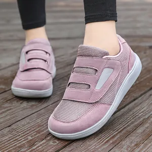 Baskets de marche mauves avec double fermeture velcro pour seniors sur bois.