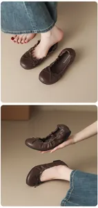 Close-up detail of brown French-style ballet flats featuring a decorative bow and soft flexible sole