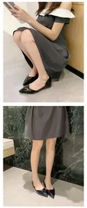 Detailed view of elegant black patent leather pointed-toe d'Orsay flats worn by model
