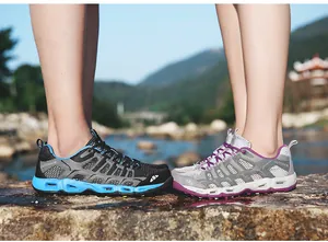 Macro detail of breathable outdoor hiking shoes for couples in a natural riverside setting