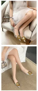 Close-up detail of silver pointed-toe flats with chunky gold buckle worn by model