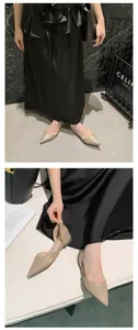 Detailed view of elegant nude French style pointed-toe d'Orsay flats worn by a model in a studio