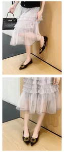 Detailed view of women's black pointed-toe flat shoes featuring a large gold buckle