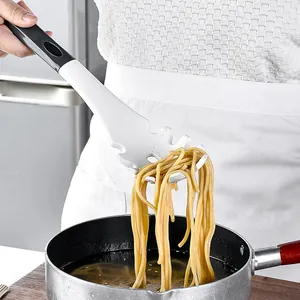 Servidor de pasta de silicona blanca profesional levantando fideos de una olla de cocina