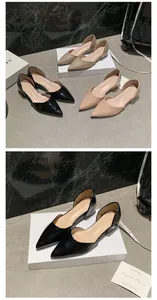 Close-up detail of elegant black patent leather pointed-toe flats in D'Orsay style.