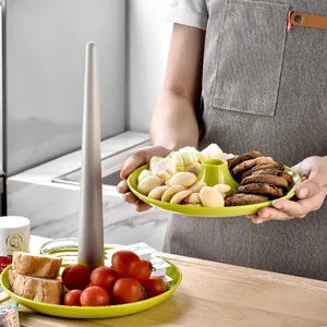 Two-tier detachable green plastic dessert stand for fruit and snacks in a kitchen setting