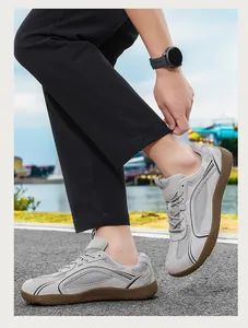 Vista dettagliata di sneakers casual in mesh grigio da uomo con suole in gomma marrone.
