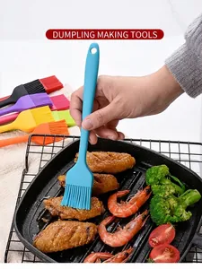 Detail of a blue silicone basting brush applying sauce to grilled meat and shrimp in a pan.