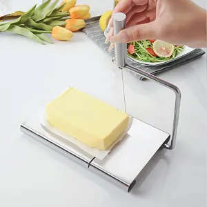 Stainless steel cheese slicer with wire for butter cutting on a marble countertop