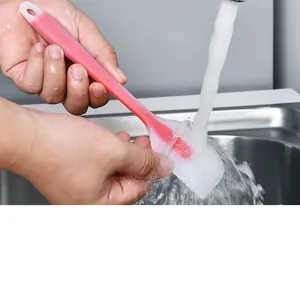 Macro view of cleaning a small translucent red silicone baking spatula under running water