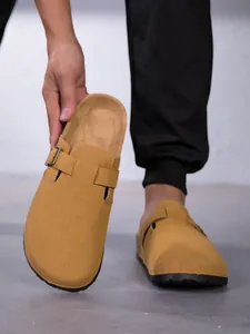 Gros plan de sabots en daim jaune avec boucle réglable et assise plantaire en liège