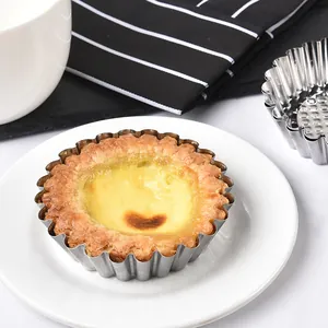 Reusable 430 stainless steel egg tart mold with baked tart on a white plate