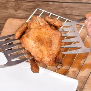 Stainless steel meat claws lifting a roasted chicken for BBQ shredding