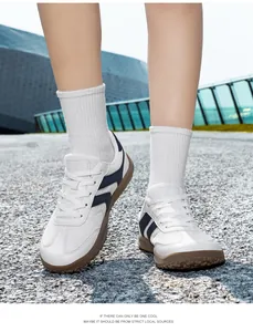 White and navy fly-knit mesh German training sneakers worn outdoors