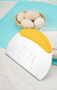 Close-up of stainless steel dough scraper with yellow handle and measurement conversion table