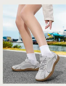 Primo piano di sneakers GAT grigie da uomo indossate su un sentiero asfaltato all'aperto.