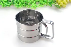 Close-up view of a stainless steel handheld flour sifter featuring engraved measurement scales.
