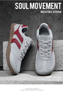 Detailed view of grey and red breathable fly-knit mesh German trainers on concrete