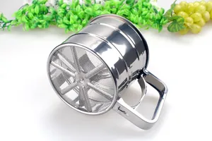 Macro detail of a handheld stainless steel flour sifter showing the fine mesh and handle