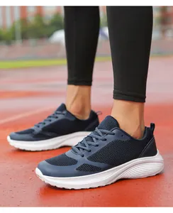 Detail shot of navy blue breathable mesh men's running shoes on a red athletic track.