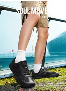 Detail shot of black fly-knit German Army Trainers on a model outdoors in the sun.