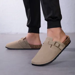 Détail de sabots en liège suédé kaki avec boucle métallique réglable portés aux pieds