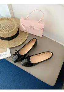 Close-up detail of black patent leather ballet flats with elegant bow and soft sole