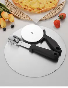Close-up view of stainless steel pizza peel and cutter wheel set on table