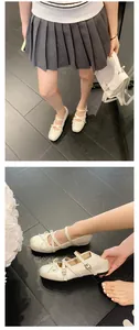 Close-up detail showing the bow and buckle straps of white Mary Jane ballet flats