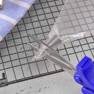 Disposable clear PE pastry piping bag being cut with scissors for cake icing decorating