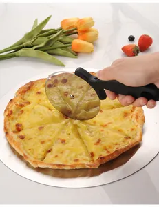 Action shot of a stainless steel pizza wheel cutter slicing a fresh cheese pizza on a peel