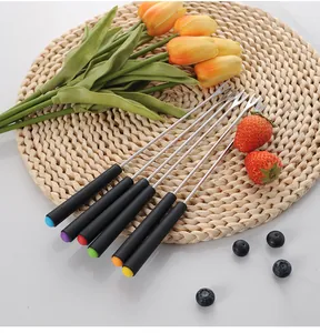 Set of 6 stainless steel fondue forks with color-coded handles on a woven table mat