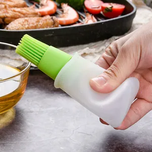 Flexible silicone oil bottle brush with integrated dispenser for kitchen grilling and baking.