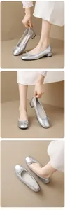 Close-up detail of silver ballet flats with round toe and bow on a model feet