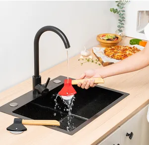 Detailansicht eines axtförmigen Pizzaschneiders, der unter dem Wasserhahn gespült wird