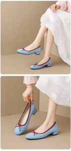 Elegant light blue suede ballet pumps with red trim and decorative bow on block heel