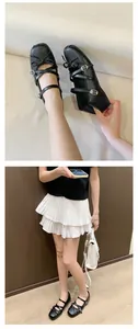 Detail view of black French ballet flats featuring bow accents and multiple Mary Jane straps