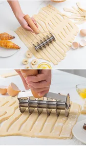 Action shot of a stainless steel lattice dough cutter rolling over pastry dough