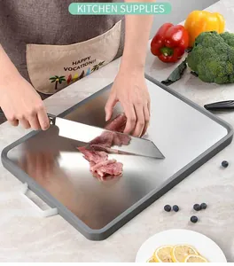 Detail view of 304 stainless steel cutting board used for slicing fresh meat in kitchen.