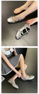 Detail of silver ballet flats with bow and multi-strap design on dark wood floor