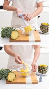 Manual plastic pineapple corer slicer tool creating spiral fruit slices in kitchen.