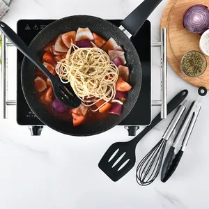 Professional 10-piece black silicone cooking utensil set with a frying pan on the stove.