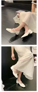 Close-up of elegant cream French Mary Janes with block heels and rhinestone straps