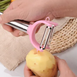 Pink stainless steel dual-head vegetable peeler being used to peel a potato.