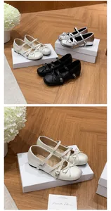 Elegant French style ballet flats with dainty bow and cross strap detail on white boxes