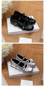 Detailed view of black and silver Mary Jane ballet flats with bow and buckle straps