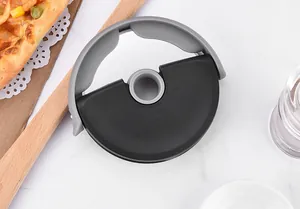 Top view of circular roller pizza cutter with ergonomic black and gray handle on table