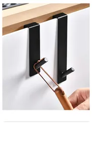Detailaufnahme schwarzer Edelstahl-Türhaken, die an einem weißen Schrank hängen